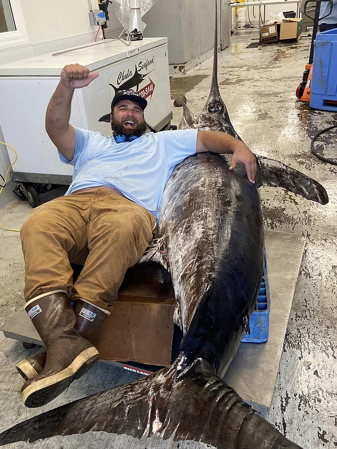 Marson Karafa with his pending state record 520-pound swordfish.