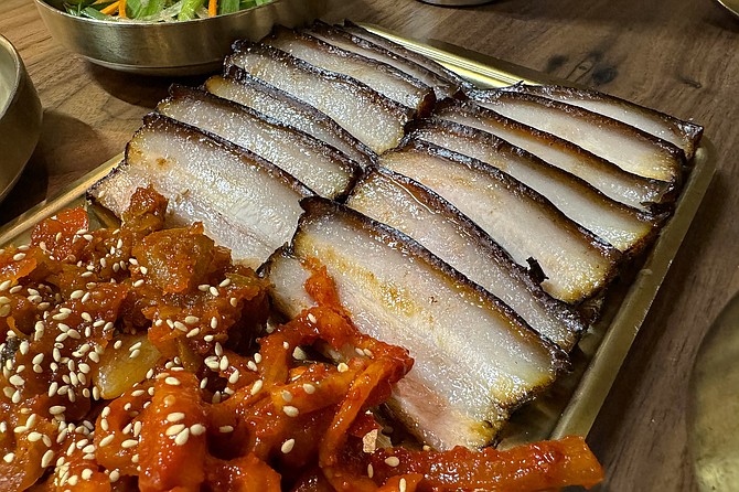 Bossam: slices of tender boiled pork belly to wrap in cabbage and fermented vegetables
