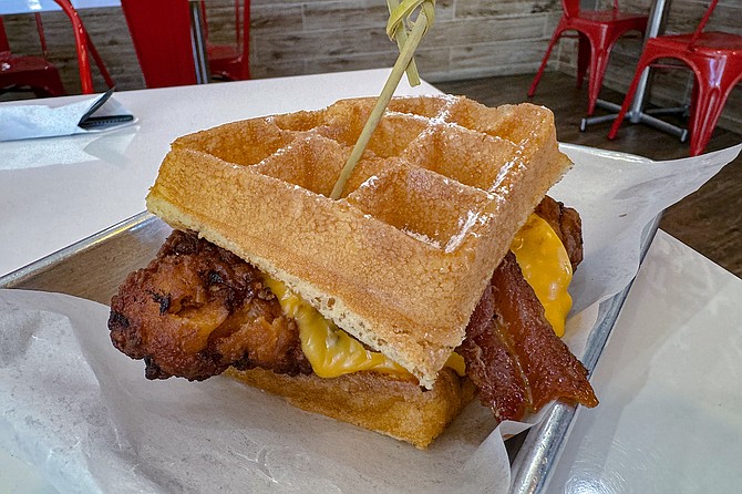 A fried chicken, bacon, and cheese slider, on waffles