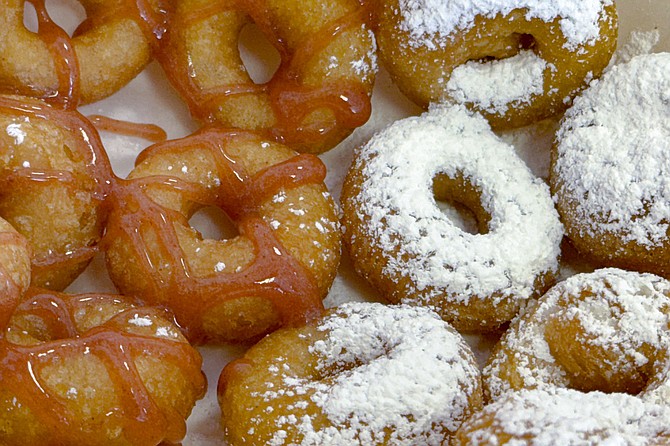 A dozen mini donuts mixed between strawberry glaze and powdered sugar