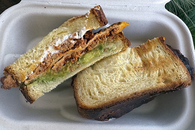 "The San Diegan," a breakfast sandwich featuring chorizo omelet, avocado, and cream cheese on slices of "croissant loaf"