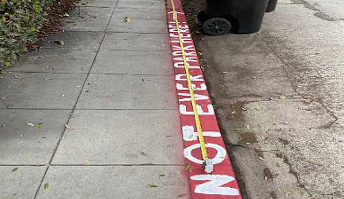 A La Jollan painted a curb red and painted in white over the illegal red paint, "Don't ever park here."