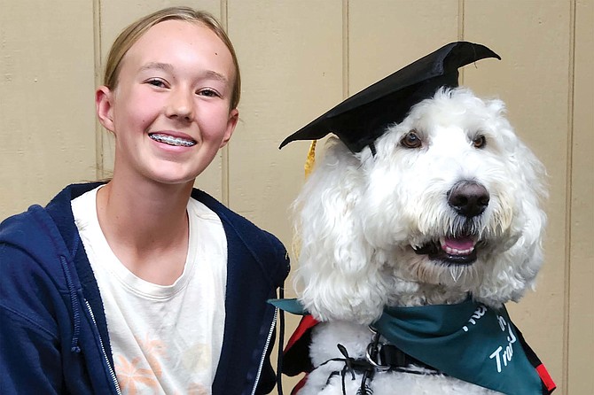 After six weeks of training, Goldendoodle Huck earns a therapy dog certificate with his handler, Madeline.