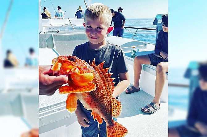 This youngster seems a bit shy, and rightly so, of his sculpin caught while fishing aboard the Premier.
