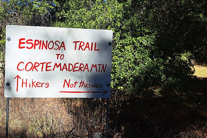Freshly painted sign pointing hikers to the peak.