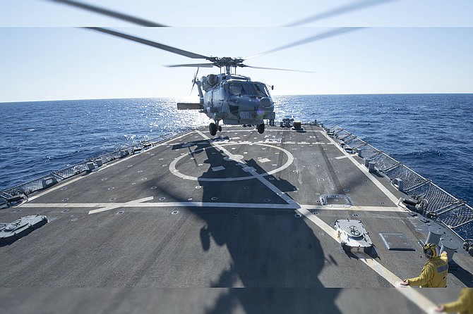 An SH-60R Seahawk helicopter takes off from the flight deck of the guided missile destroyer USS Stout