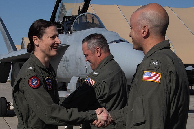 Cmdr. Kristen Hansen, commanding officer, Strike Fighter Squadron (VFA) 122, shakes hands at the change of command ceremony at Naval Air Station Lemoore.