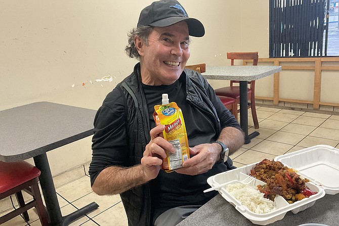 Kevin with his mango juice and kaldereta, an old Spanish beef stew