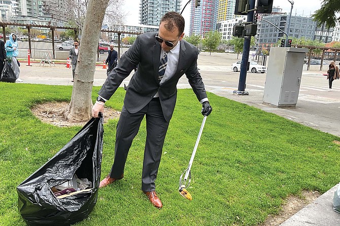 Trevor Spence picks up a banana skin outside 12th and Imperial Transit.
