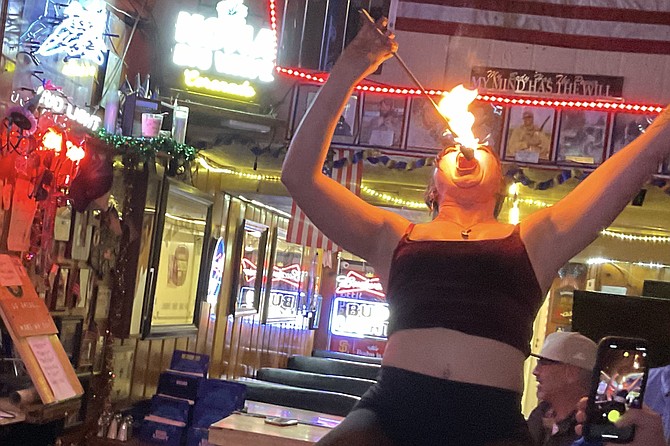 Maggie Starfire puts flames in her mouth, very carefully, at Danny’s Bar.
