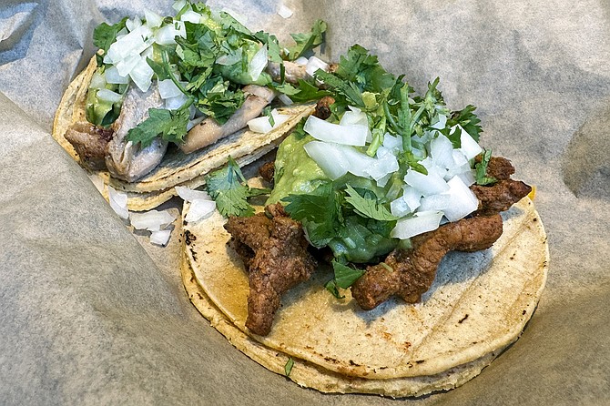 An adobada taco (front) and pollo asado taco
