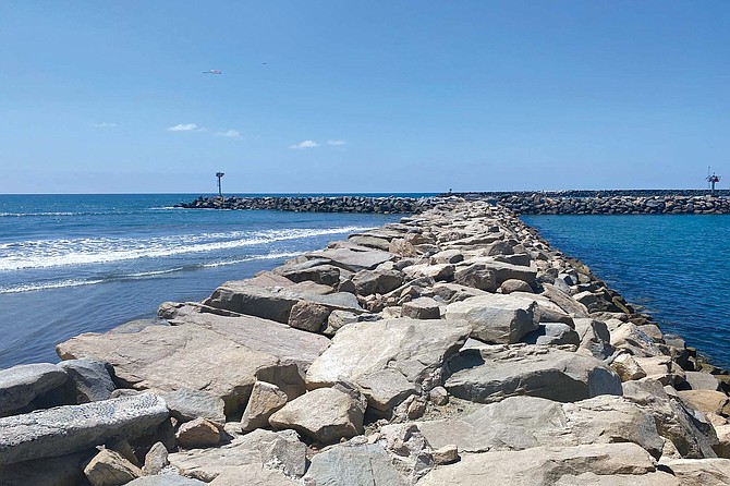 The large jetty that protects the two harbors in Oceanside, which share an entrance to the ocean, creates a barrier that blocks the sand that would naturally be carried south by ocean currents.