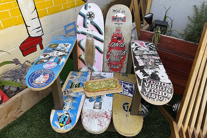 A pesto chicken flatbread, and an Adirondack chair made from used skate decks