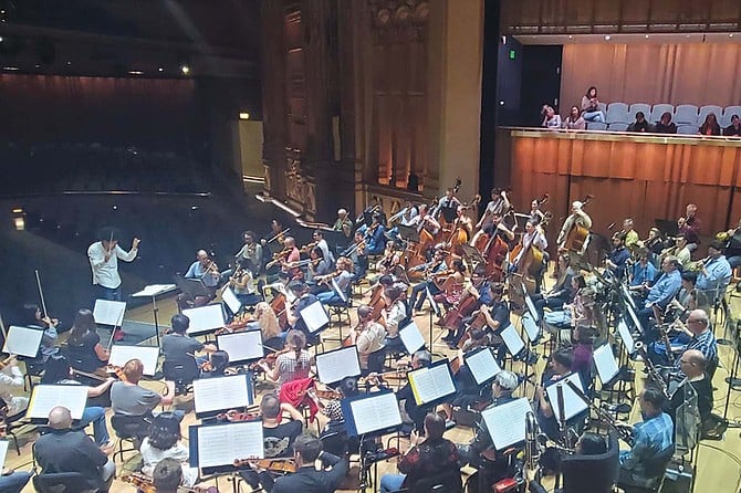 Rafael Payaré conducts the orchestra in rehearsal.