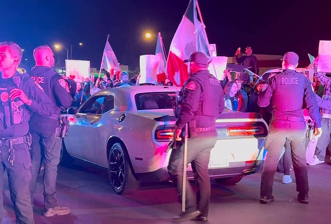 A protest crowd forced police out of a parking lot on the 600 block of North Escondido Boulevard. (New Flash Media)
