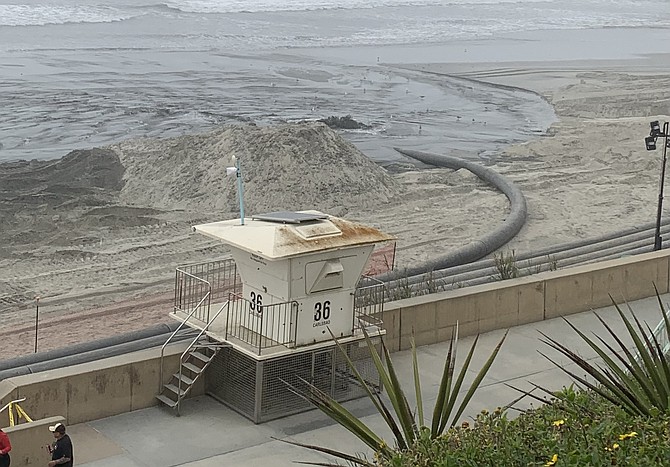 Sand is pumped onto beach near Cherry Street