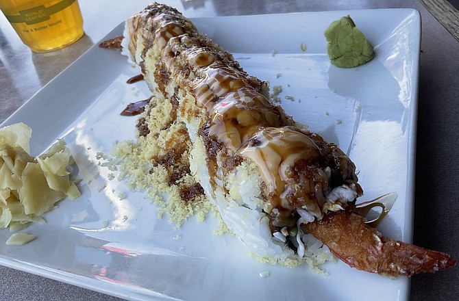 The “secret” sauces on top give a sweet-savory flavor to the fried shrimp sushi.