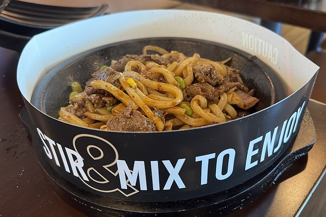 A wagyu beef and udon noodle dish that cooks at your table