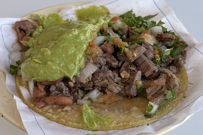 Carne asada taco, made standard with guacamole and beans