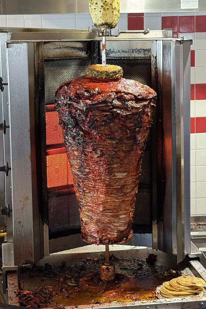 The Tacos El Franc *trompo*, or rotisserie, that roasts pork adobada under dripping pineapples at Plaza Bonita mall