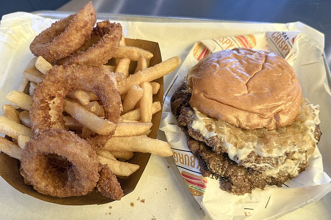 An Original "OG" Crispy Burger with fries and onion rings