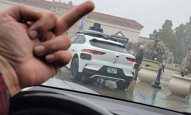 Carlos Medina posted a photo: him flipping off a driverless Waymo.